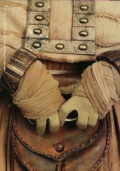 a close up of a leather bag with gloves on it's shoulder and belt around the waist