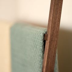 a close up of a wooden chair with a blue blanket on it's back