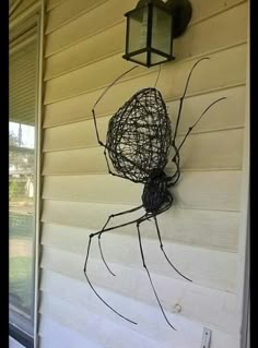 a spider is attached to the side of a house with a light on it's head