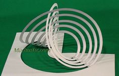 white paper cut out into spirals on a green background