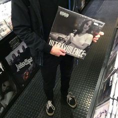 a man holding up a cd in front of his face while standing next to another person