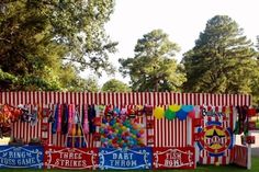 a carnival booth with balloons and signs on it