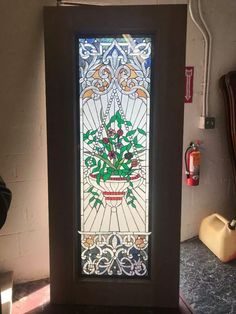 a stained glass window in the corner of a room next to a vase with flowers on it