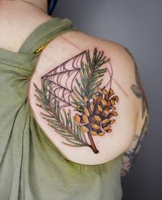 a woman with a tattoo on her shoulder holding a pine cone