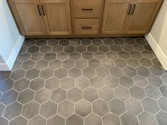 a bathroom with hexagonal tile flooring and wooden cabinets in the backround