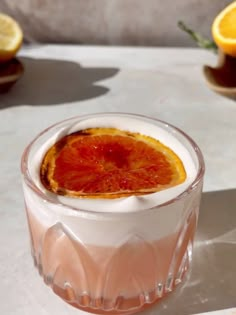 a drink with orange slices in it sitting on a table