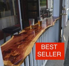 two glasses sitting on top of a wooden counter next to a building with windows and doors