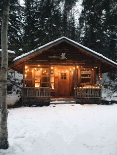 a small cabin is lit up with christmas lights