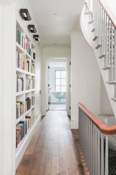 a long hallway with bookshelves and stairs