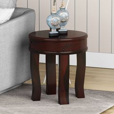 a wooden table with two blue vases on it and a white couch in the background