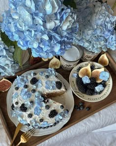 blue hydrangeas and cake on a tray next to plates with slices of pie