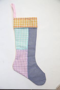 a stocking hanging on the wall with different colored plaid patterns and gingham fabric