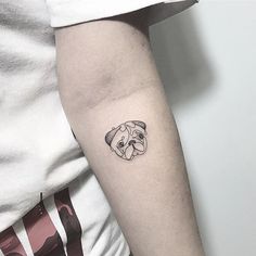 a small pug tattoo on the left arm