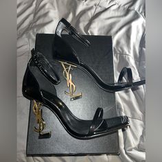 New! Yves Saint Laurent Opium Heels Size 6.5.. Black Patent Leather With Gold.. Sticker Under Heel To Preserve Haven’t Worn, Only Try On Inside The House!!! Comes With Box & Shoe Bagprice Is Firm, These Heels Are Very Expensive To Be Low Balling! To Ppl That Are Questioning; Do Your Research: The Bottom Of These Shoes Are A Protective Sticker That’s Attached To Preserve The Shoes So No They Have Not Been Worn!!! It’s How I Received When I Purchased These Were Purchased Here Through Another Poshe Black Heels With Gold Accent, Gold Heels Black Dress, Shoe Inspo Heels, Cute Heels Aesthetic, Knife Heels, Expensive Heels, Yves Saint Laurent Heels, Black Heels Pumps, Strap Heels Black