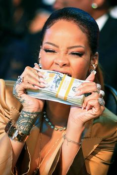 a woman with tattoos holding up a stack of money