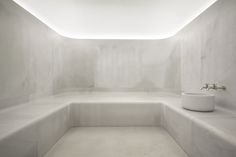 a white bathroom with concrete walls and floor