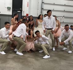 a group of people standing around each other in front of a man wearing a white shirt and khaki pants