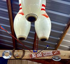 an old fashioned bowling ball lamp hanging from the ceiling with no bad cussin sign on it