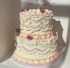 a three tiered cake with cherries on top