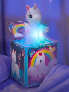 a stuffed animal sitting on top of a toy box with lights in the shape of unicorns