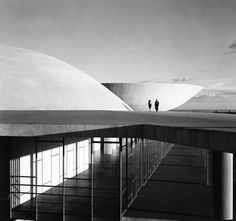 black and white photograph of two people standing at the top of a building with columns