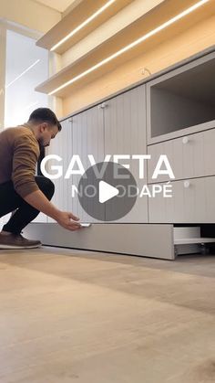 a man kneeling down on the floor in front of a cabinet with words that say gav eta to cape