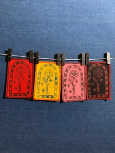 four different colored cards hanging on a clothes line