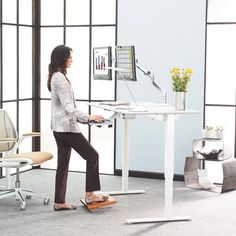 a woman standing in front of a computer desk