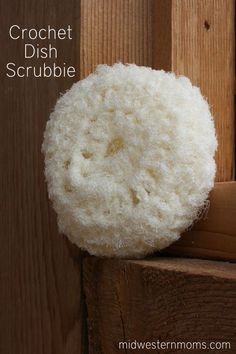 a crochet dish scrubbie sitting on top of a wooden door