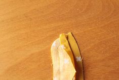 a piece of yellow fabric sitting on top of a wooden table