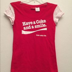 a red shirt that says have a coke and a smile