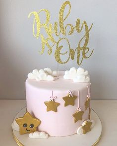 a pink and gold cake with stars on top