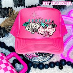 a pink trucker hat sitting on top of a table next to other items and accessories