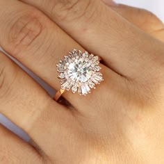 a woman's hand with a diamond ring on top of her finger and an engagement band