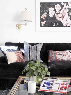 a living room filled with black couches and pillows