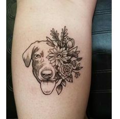 a black and white dog with flowers on it's side tattooing its face