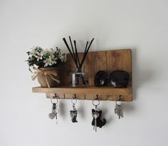 a wooden shelf with key hooks and flowers on it