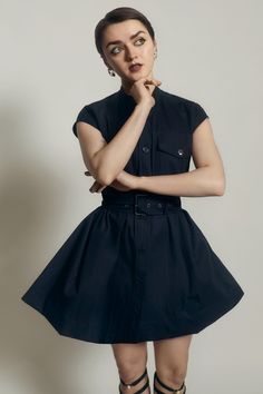 a woman posing with her hand on her chin and looking at the camera while wearing high heels