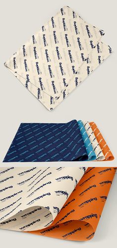 four different colored ties laying next to each other on a white surface with blue and orange designs