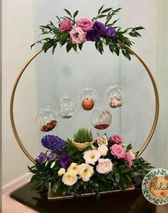 an arrangement of flowers is displayed in a circular display case with glass globes on top