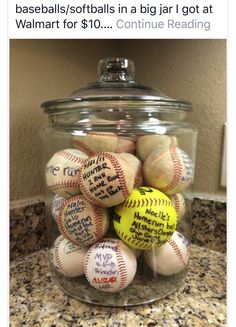 a glass jar filled with baseballs on top of a counter