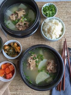 several bowls of food on a mat with chopsticks