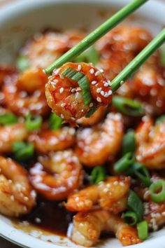 shrimp with sesame seeds and green onions in a white bowl