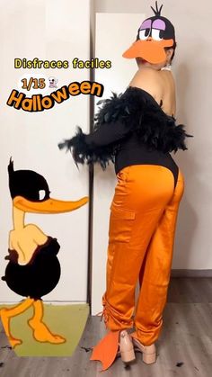 a woman in an orange pants and black top standing next to a cardboard cutout of a cartoon duck