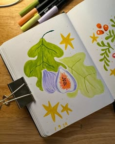 an open notebook with watercolors on it