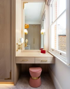 a bathroom with a vanity, mirror and stool in front of a window on the wall