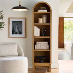 a living room with a white chair and book shelf