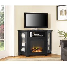 an entertainment center with a flat screen tv on top of it and a fire in the fireplace