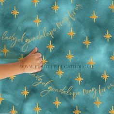 a child's hand on a blue background with gold stars