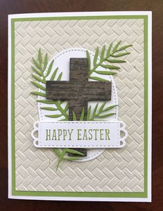 a card with a cross on it and some green leaves around the edge that says happy easter